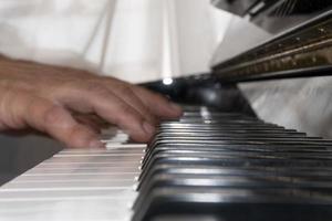 Hands playing piano while moving photo