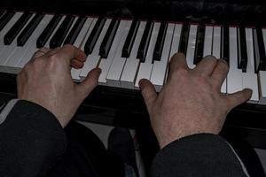 Hands playing piano while moving photo