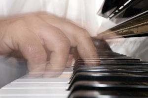 Hands playing piano while moving photo