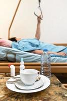 dishes on table and patient holding handle on bed photo