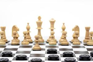 black checkers disc attacks white chess pawn photo