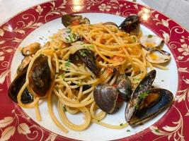 spaghetti with mussels and clams on plate close up photo