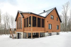 invierno cabañas en remoto zona quebec, Canadá, Iniciar sesión casa con sauna, spa, dormitorios, piscina, vivo habitación, mesanina, cocina y baños foto