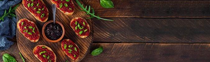 Bruschetta with grated beetroot, herbs and caramelized onion. Top view photo