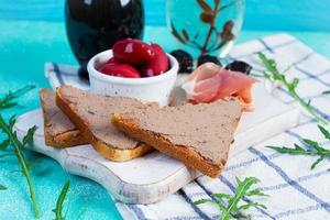 Grilled sandwich with pate with chicken liver and olives on blue background photo