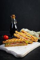 club emparedado con jamón, tomate, verde y queso. A la parrilla panini foto