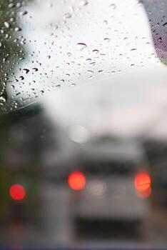 Soft Focus,Raindrops on the windshield are raindrops created by a passing storm and affect visibility when driving on the road because raindrops on the windshield make vision difficult. photo