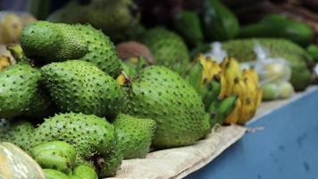 Fruits and vegetables at a tropical market in the rain video