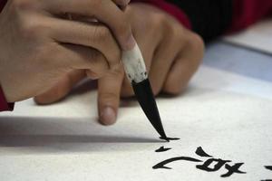 japanese woman writing name Elisabeth in ideograms with brush photo