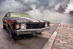 Old seventies Car in a tornado background photo