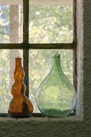 Empty bottles near a window photo
