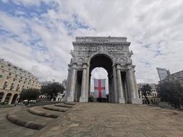 triunfo arco en Génova con bandera rojo cruzar en blanco foto