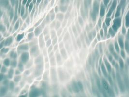 desenfoque borroso transparente color azul claro agua tranquila textura superficial con salpicaduras y burbujas. fondo de naturaleza abstracta de moda. ondas de agua a la luz del sol con espacio de copia. acuarela azul brillante foto