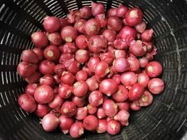 shallots in black baskets for sale in the market photo