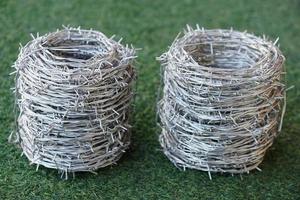 Rolls of barbed wire. Barbed wire is used for make fences , secure property and make border to show the territory of  area. photo