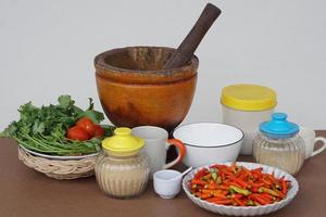 Preparing food ingredients and equipment for cooking, pestle and mortar, vegetables, jars and cups.Concept, Thai traditional cooking style. photo