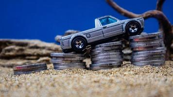 minahasa, Indonesia  January 2023, toy car on a pile of coins, saving for the future, managing successful transportation business technology concept photo