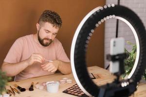 hombre hacer arriba vlogger grabación transmitir acerca de productos cosméticos y tutoriales para maquillaje artista foto