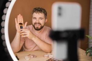 Portrait bearded man making vlog review cosmetics product and channel recording video make up tutorial making at home - Online influencer guy and social media market live steaming concept photo