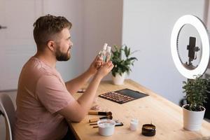 Man make up vlogger recording broadcast about cosmetics and tutorials for make-up artist photo