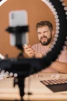 Bearded man professional beauty make up artist vlogger or blogger recording makeup tutorial to share on website or social media. photo