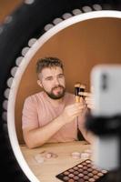 Man make up vlogger recording broadcast about cosmetics and tutorials for make-up artist photo
