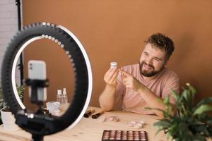 hombre hacer arriba vlogger grabación transmitir acerca de productos cosméticos y tutoriales para maquillaje artista foto