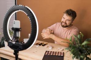 hombre hacer arriba vlogger grabación transmitir acerca de productos cosméticos y tutoriales para maquillaje artista foto