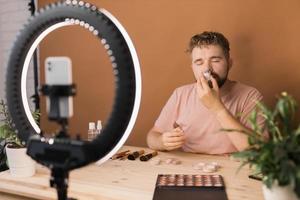 Man make up vlogger recording broadcast about cosmetics and tutorials for make-up artist photo