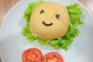 smiley face delicious burger on the wooden table top view photo
