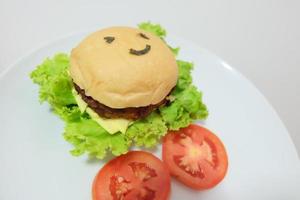 sonriente cara delicioso hamburguesa en el mesa foto
