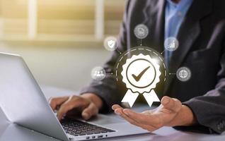 Businessman working on laptop with check mark symbol and standard quality control. The concept of international standards and quality assurance is certified photo