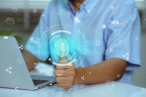 Using fingerprint scanning, the businessman accesses and unlocks the cloud data network. Cyber security and biometric identification protect business transactions from online cyber attacks photo