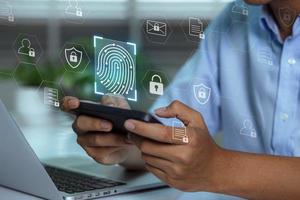 A user accesses document data via a laptop and smartphone equipped with a fingerprint scanner. Cyber security and data protection information privacy internet technology photo