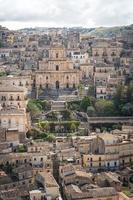 Modica, Italy-May 8, 2022-Panoramic view of the characteristic city of Modica and its cathedral of San Giorgio in Sicily during a cloudy day photo