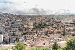 Modica, Italy-May 8, 2022-Panoramic view of the characteristic city of Modica and its cathedral of San Giorgio in Sicily during a cloudy day photo