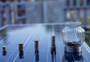 silver coin on solar panel Cells help store solar energy.Then used to produce electricity for homes and buildings to use, reducing costs and preserving the environment.that helps reduce global warming photo