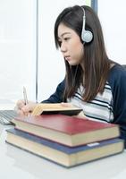 Young female long hair sitting in living room and learning online photo