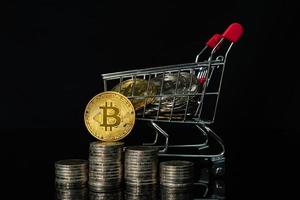 moneda bitcoin en carrito de compras con fondo negro foto