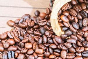 Barril de madera con montón de granos de café tostado foto