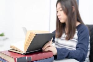 Young female sitting in living room and learning online photo