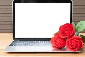 Red rose and laptop mockup on wood photo