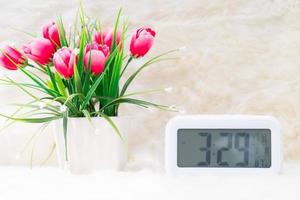 Digital clock with flora decorated on table photo