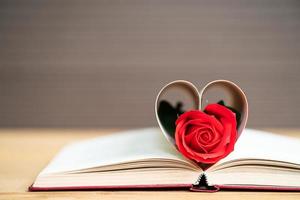 páginas de libro en forma de corazón curvo con rosa roja foto