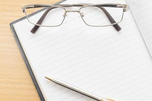 Notebook open blank page and Eyeglasses photo