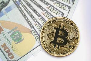 Bitcoin coins and  US banknotes of one hundred dollars photo