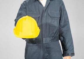 Close up Worker standing in blue coverall holding hardhat photo