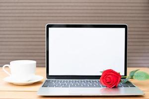 Red rose and coffee cup with laptop mockup on wood photo