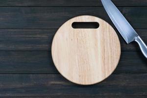 Close up kitchen knife and wooden round cutting board photo