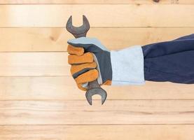 Hand in glove holding hammer photo